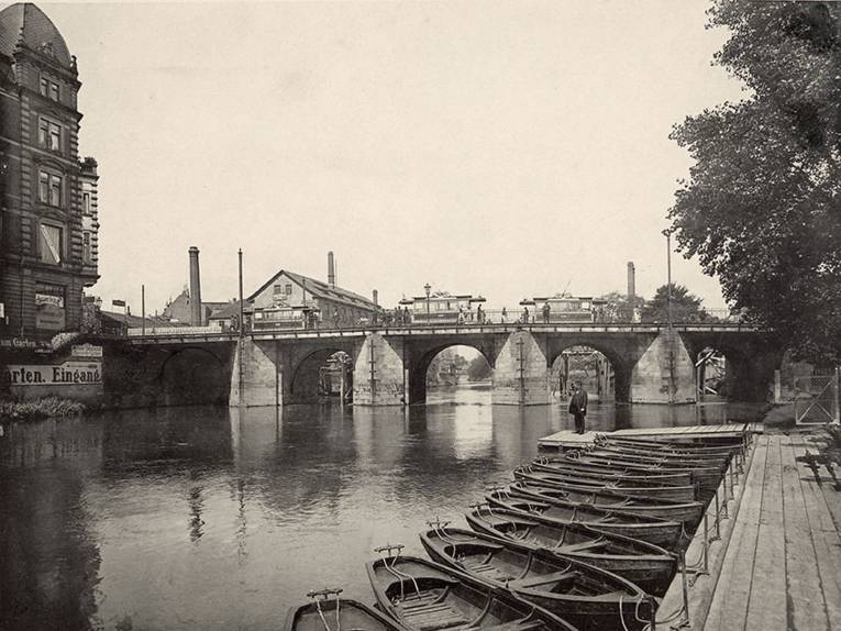 Ihmebrückstraße. Die alte Ihmebrücke (abgebrochen im Juni 1910) am Schwarzen Bären. Im Hintergrunde die im Bau befindliche Notbrücke für den Verkehr während der Brückenbauzeit, Lichtdruck nach Foto vor 1910