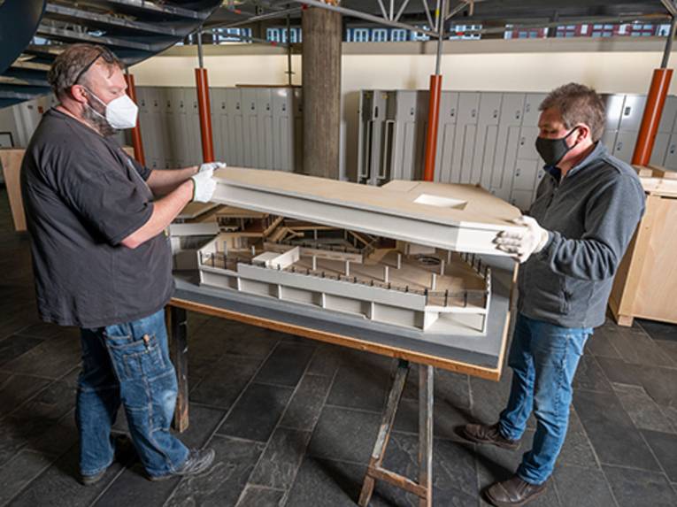 Museumsmitarbeiter beim auseinandernehmen des Baumodells des Historischen Museums Hannover