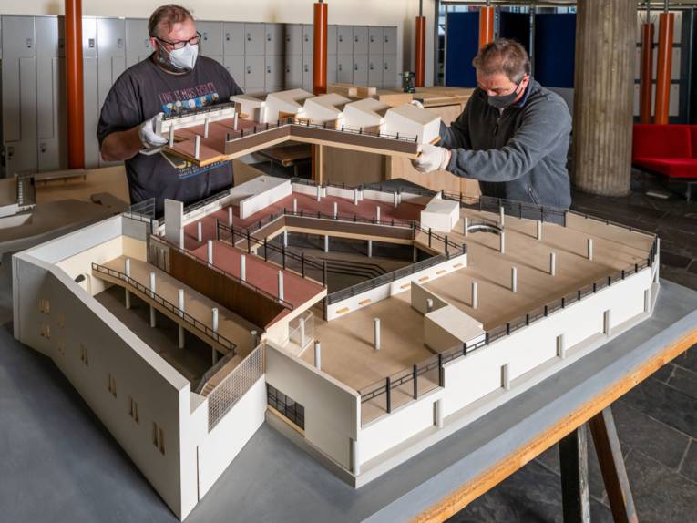 Museumsmitarbeiter beim auseinandernehmen des Baumodells des Historischen Museums Hannover