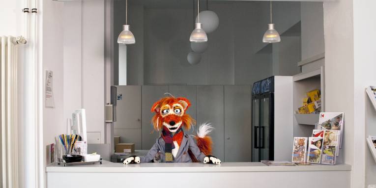 Der Kinofuchs wartet an der Kinokasse auf die Kinder