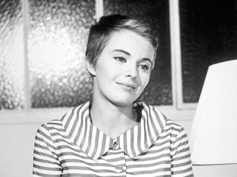 Das Bild zeigt eine junge Frau in einem gestreiften Kleid.