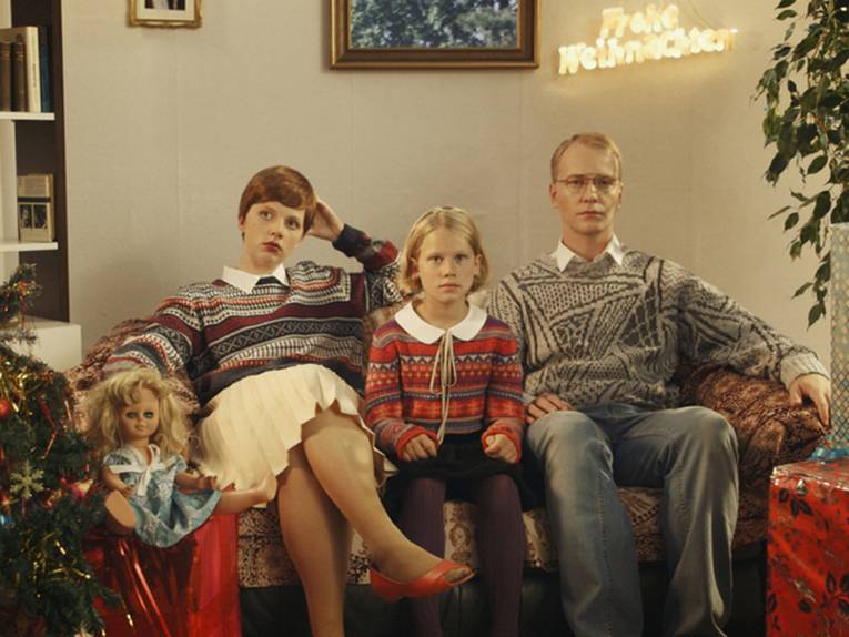 Konservativ aussehende Familie sitzt auf dem Sofa.