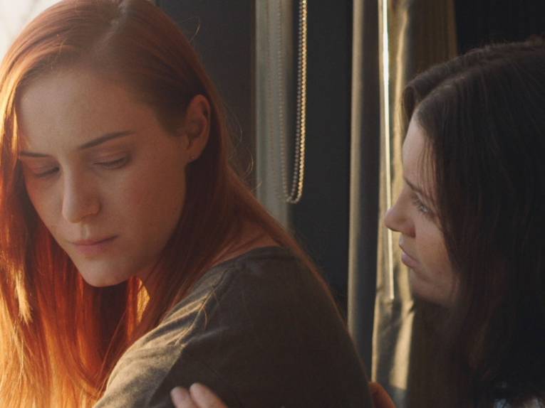 Zu sehen sind zwei Personen, die sich unterstützung geben.