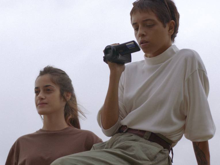 Zu sehen sind zwei Personen, eine filmt etwas mit einer Kamera.