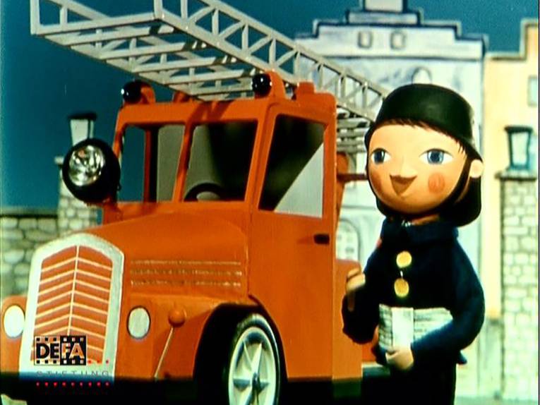 Ein Feuerwehrmann steht vor einem Feuerwehr-Leiterwagen