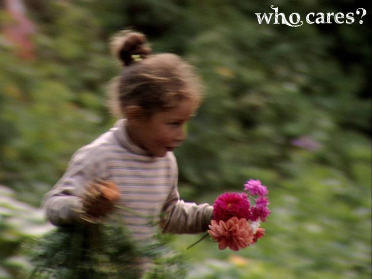 Mädchen, mit Blumen in der Hand, rennt über eine grüne Wiese.