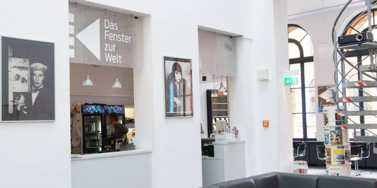 Ein Raum mit Sofas, Tischen und Stühlen und einem Kassenbereich. 