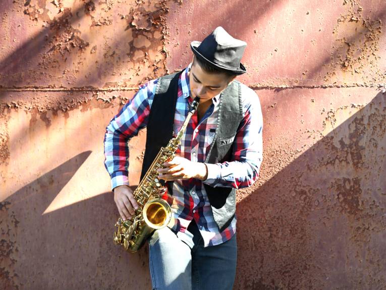 Junger Musiker spielt auf einem Saxophon
