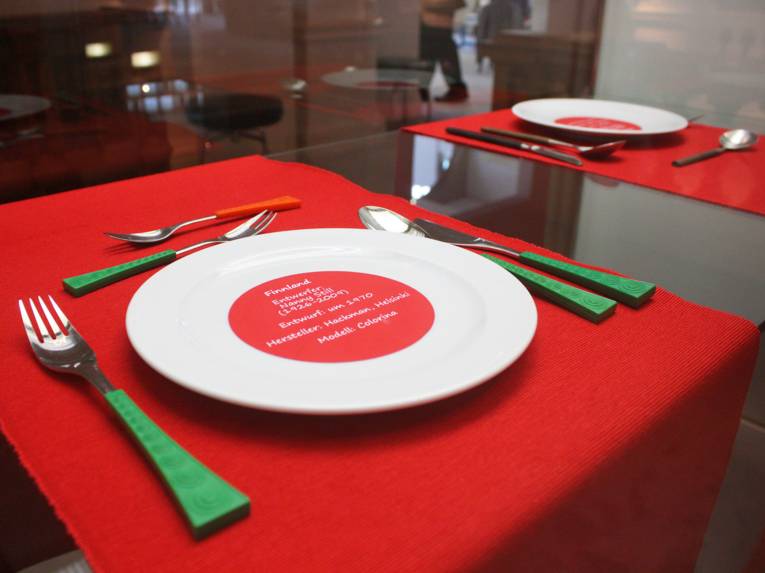 Ein Besteck mit grünen Griffen auf einer roten Unterlage