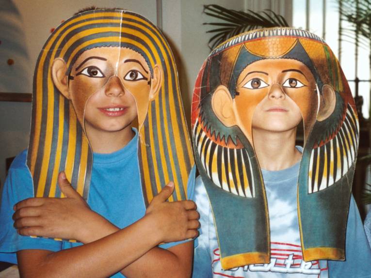 Zwei Kinder mit nachgemachten Pharaomasken