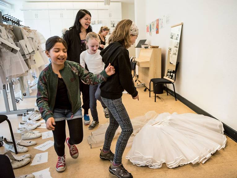 Drei Mädchen laufen in der Garderobe der Musikschule