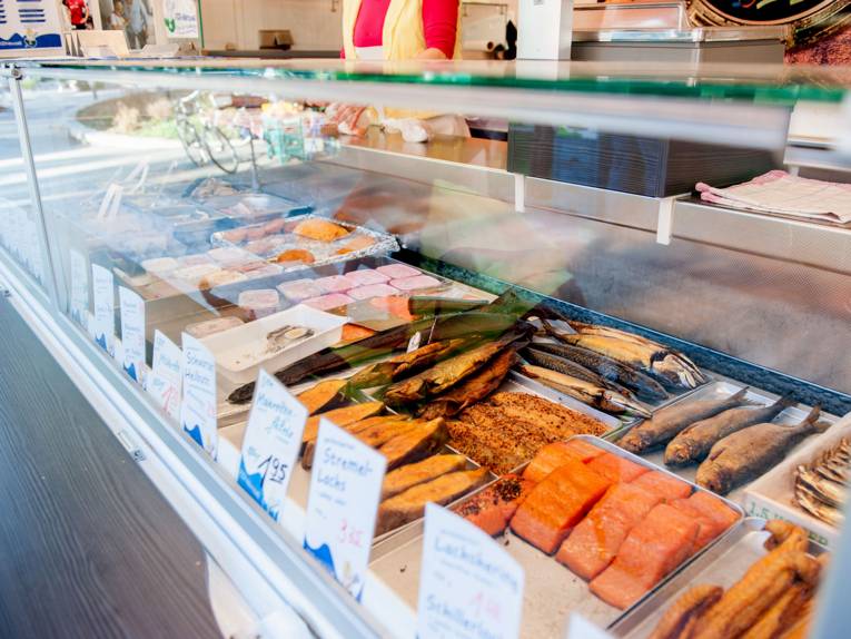 In der Auslage eines Verkaufswagens auf dem Ahlemer Wochenmarkt liegen geräucherte Fische und Fischsalate.