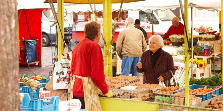 Freundliche ältere Dame im Gespräch mit einer Verkäuferin am Eierstand auf dem Wochenmarkt Rübezahlplatz