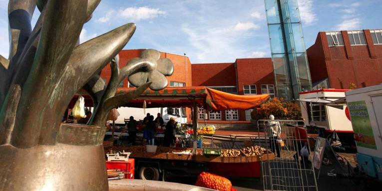 Teilansicht eines modernen Brunnens mit Marktständen