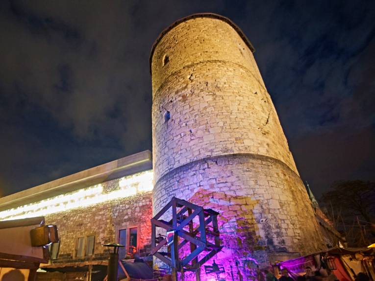Der Beginenturm am Historischen Museum wird in der Dunkelheit angestrahlt.