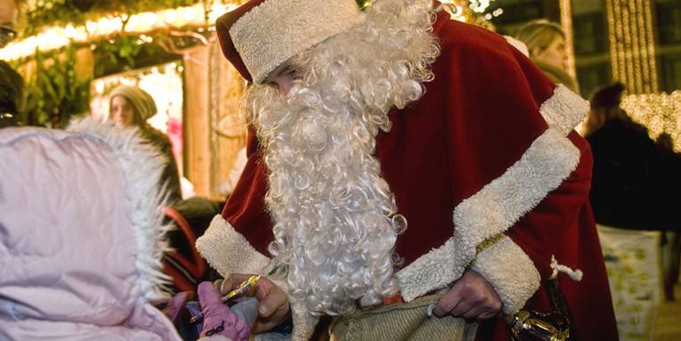 Der Weihnachtsmann überreicht einem Kind ein kleines Geschenk