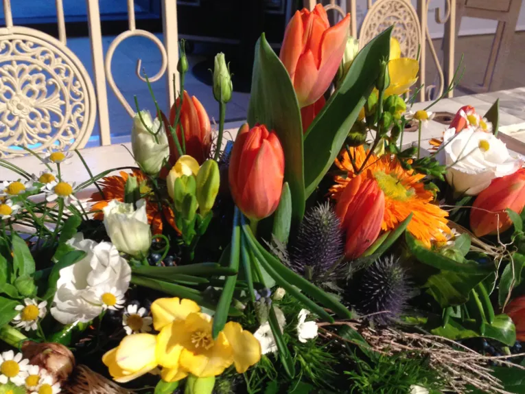 Üppiges Blumengesteck mit Tulpen, Fresien, Rosen und Schmuckpflanzen