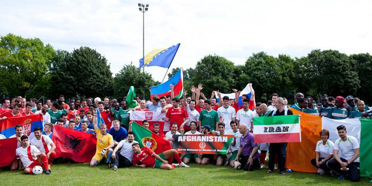 Ein große Gruppe Fußballspieler mit verschiedenen Länderflaggen