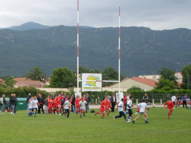 Jugendliche zweier Mannschaften jagen einem Rugby-Ball hinterher
