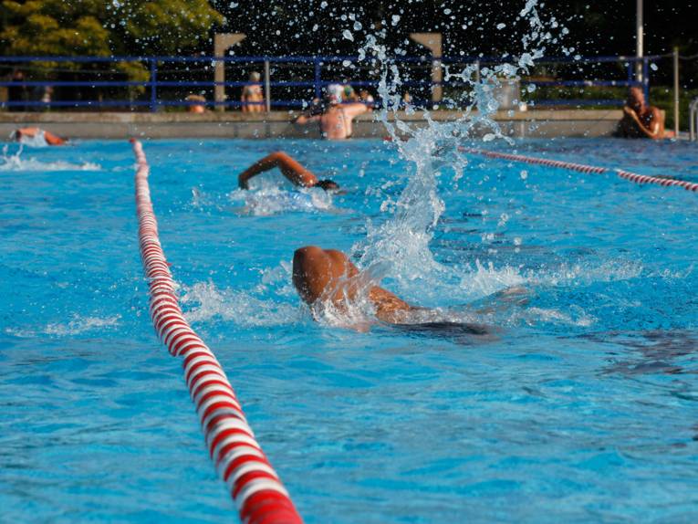 Schwimmende Menschen in einem Freibad. 