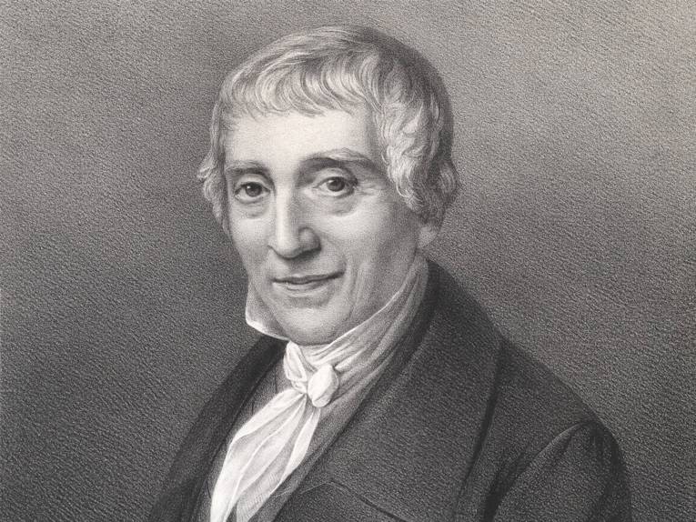 Die Lithografie zeigt das Brustbild Grotefends von links mit nach vorn gewandtem Gesicht.