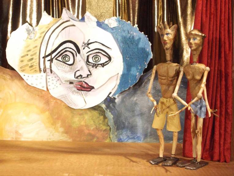 Männliche und weibliche Puppe vor einer Sonne. 