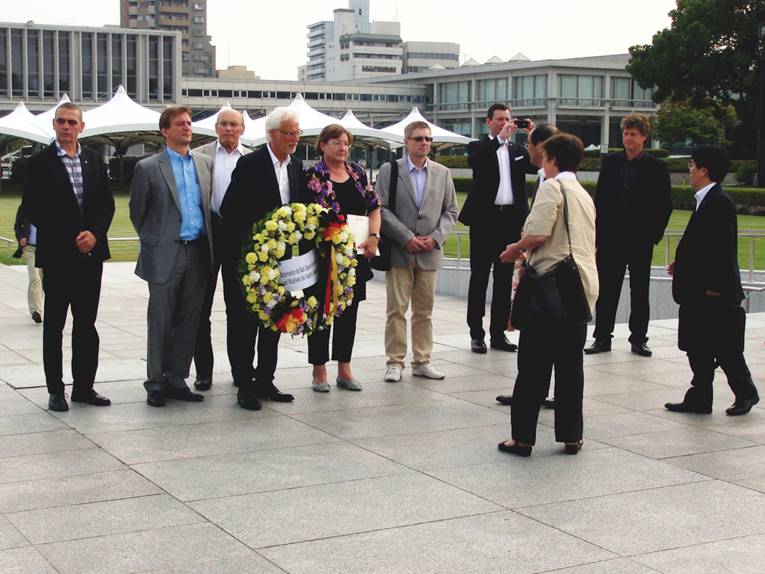 Mitglieder des Rates der Stadt Hannover in Hiroshima, Bürgermeister Strauch hält einen Gedenkkranz in den Händen