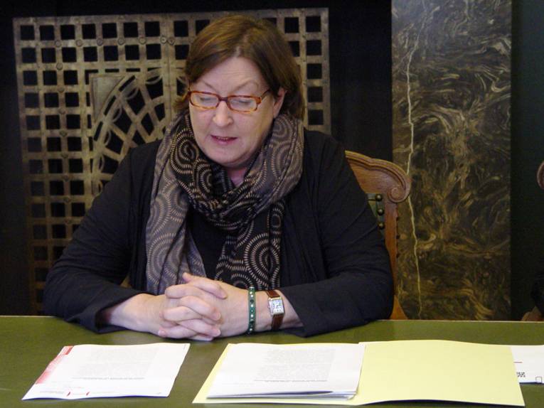 Schul- und Kulturdezernentin Marlis Drevermann an einem Tisch sitzend, vor ihr liegen diverse Unterlagen