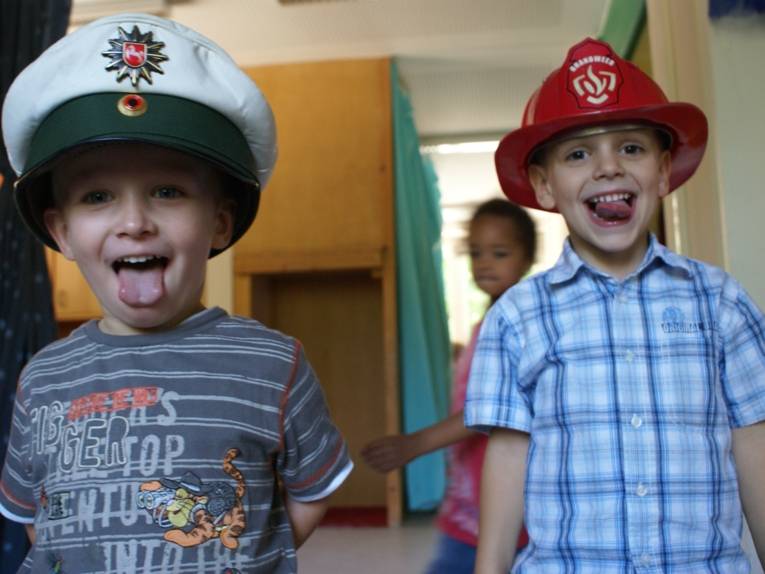Zwei als Polizist bzw. als Feuerwehrmann verkleidete Kita-Kinder