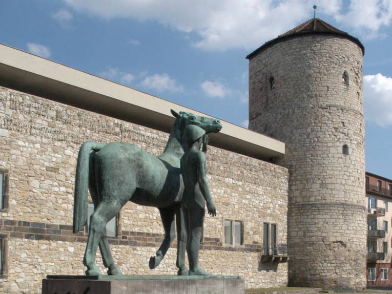 Historisches Museum mit Beginenturm. Skulptur „Mann mit Pferd“ von Hermann Scheuernstuhl, 1957.