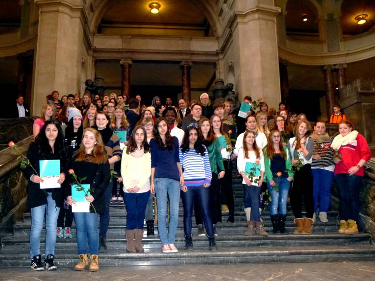 66 Jugendliche stehen gemeinsam mit Bürgermeister Bernd Strauch auf der Treppe in der Kuppelhalle des Rathauses