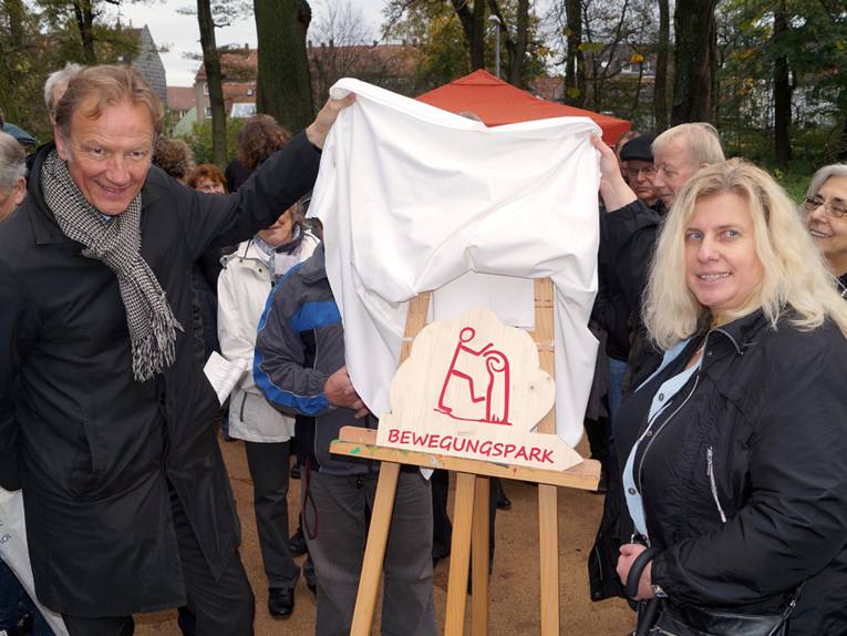 Uwe Bodemann und Marion Diener enthüllen das Info-Schild des Bewegungsparks in Stöcken