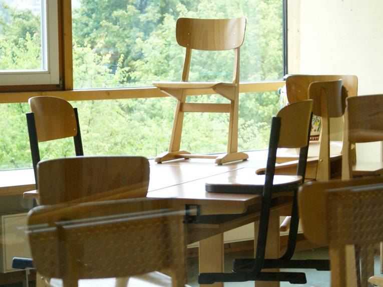 Ein Klassenzimmer, in dem Stühle auf den Tischen stehen
