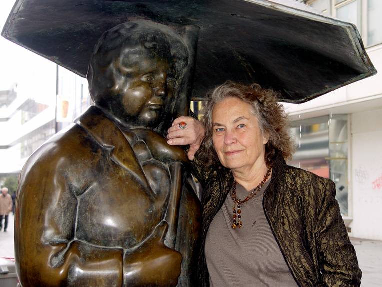 Eine Skulptur mit Regenschirm und die Künstlerin Ulrike Enders