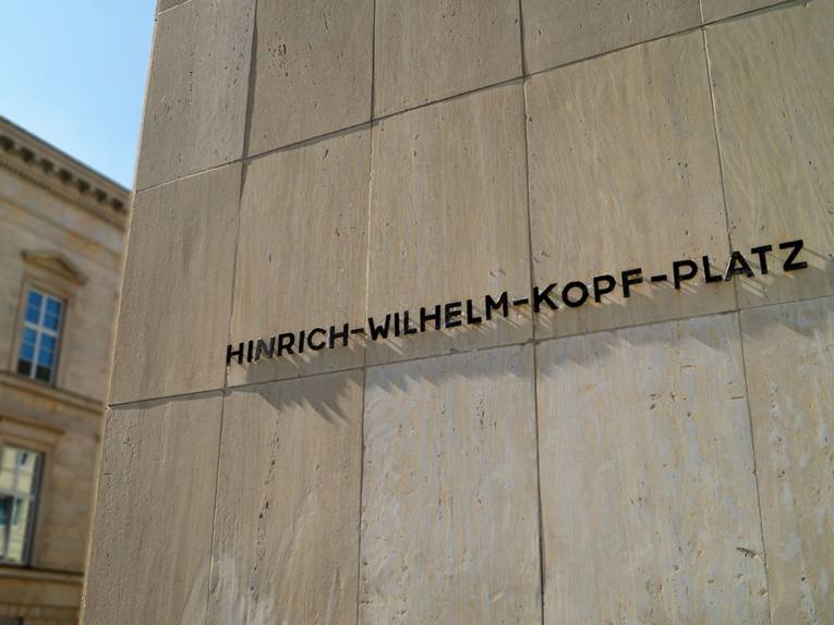 Der Schriftzug "Hinrich-Wilhelm-Kopf-Platz" an einer Häuserfassade.