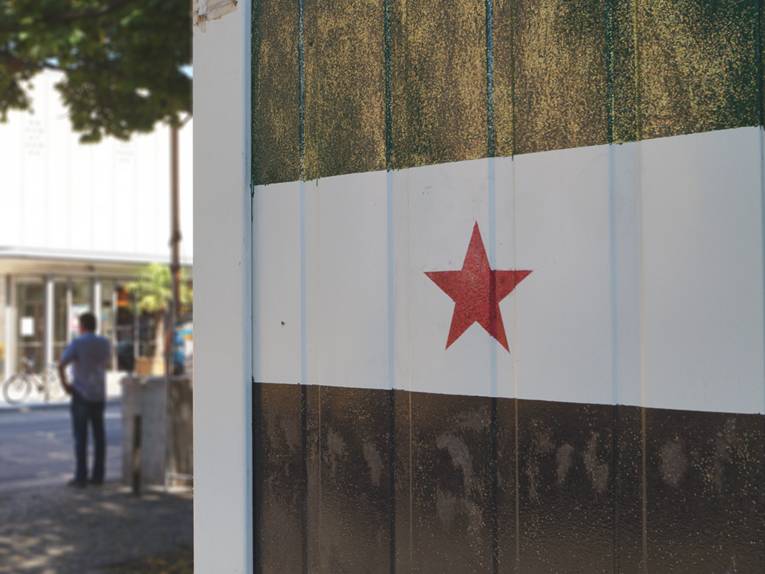 Die syrische Flagge, die auf einen Container gegenüber der Markthalle gemalt ist