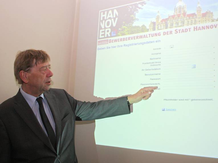 Harald Härke vor einer Leinwand mit dem Registrierungsformular für die Online-Bewerbung