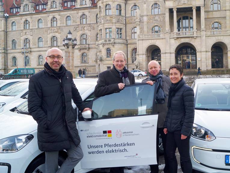 Raimund Nowak, Stefan Schostok, Silvan Koch und Sabine Flores an einem VW e-up! vor dem Neuen Rathaus