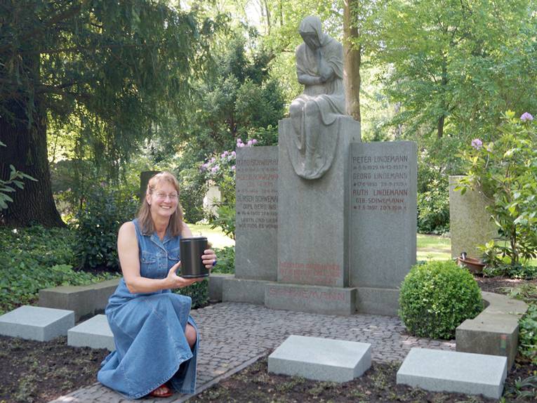 Friedhofsplanerin Kerstin Schönewald mit einer Aschenkapsel vor einem historischen Grabmal auf dem Friedhof Engesohde