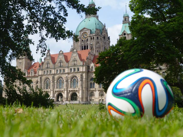 Ein Fußball liegt auf der Wiese hinter dem Neuen Rathaus