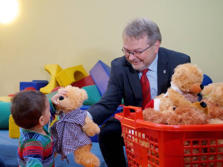 Thomas Hermann übergibt einen Teddy an einen Jungen