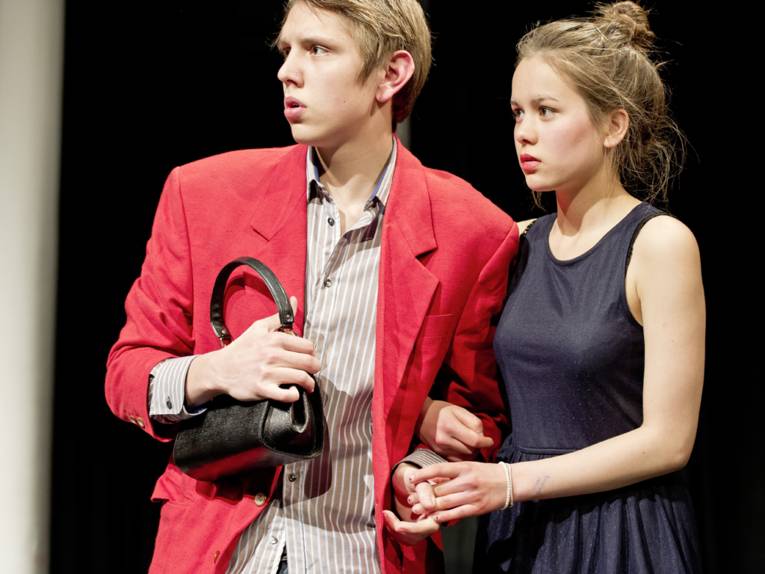 Aufnahme aus einem Theaterstück der IGS Mühlenberg, ein junger Mann und eine junge Dame blicken Hand in Hand in die Ferne