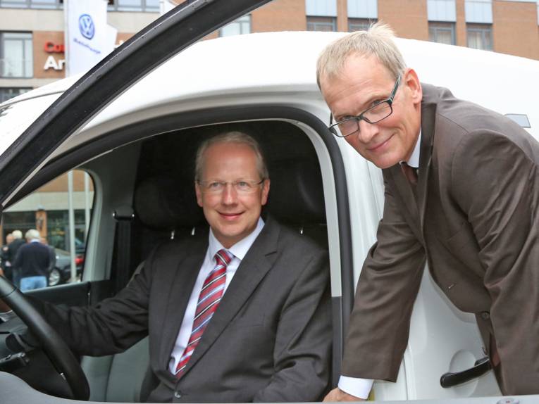 Stefan Schostok und Dr. Eckhard Scholz in bzw. an der Fahrertür eines Autos