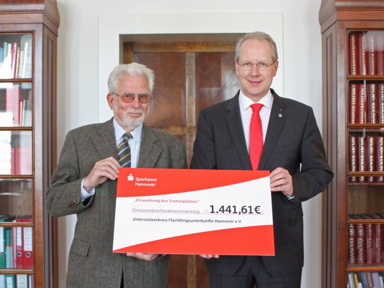 Gerhard Spitta und Stefan Schostok mit einem Spendenscheck über 1.441,61 €