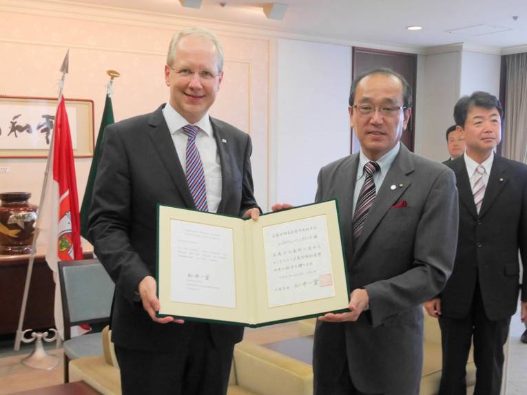 Oberbürgermeister Stefan Schostok bekommt von Hiroshimas Bürgermeister Katsumi Matsui die Ehrenbürger-Urkunde überreicht
