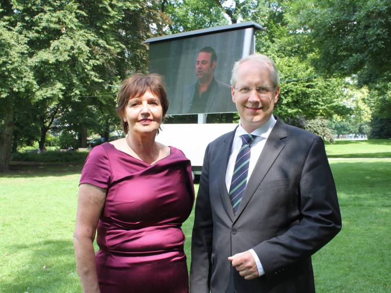 Marlis Fertmann und Stefan Schostok vor einer Videoleinwand im Maschpark