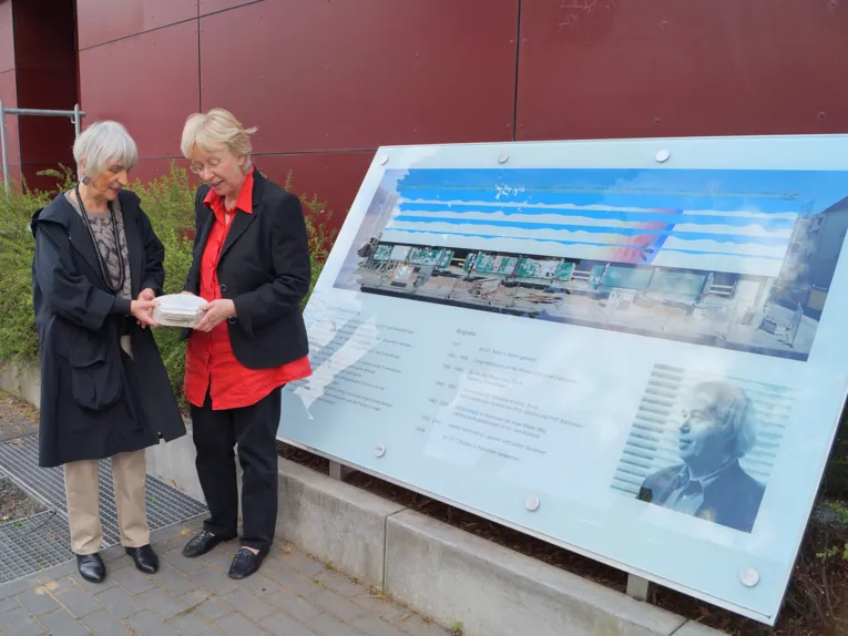 Rosemarie Würth-Beuermann und Gabriele Ciecior, die stellvertretende Leiterin des Kulturbüros, betrachten neben der Gedenktafel ein Stück des Wandbilds