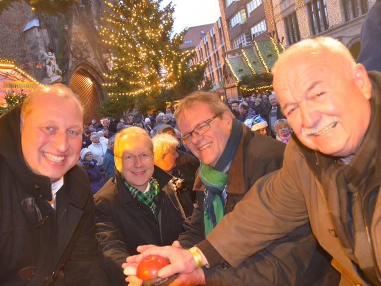 Michael Flohr vom Bereich Marktwesen, Oberbürgermeister Stefan Schostok, Stadtsuperintendent Hans-Martin Heinemann und der Präsident des Schaustellerverbandes Niedersachsen, Arthur Armbrecht, drücken den symbolischen roten Knopf zur Eröffnung des Weihnachtsmarktes an der Marktkirche in Hannover