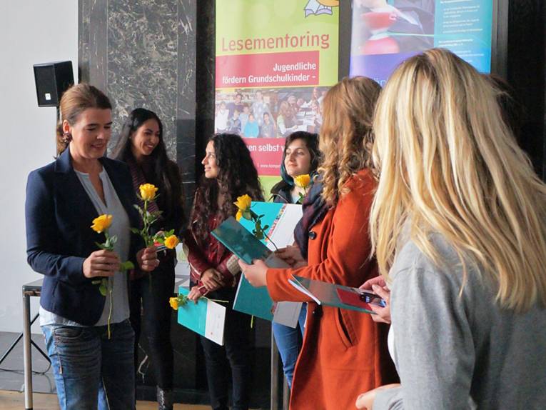 Susanne Daubner verteilt Blumen an einige Jugendliche