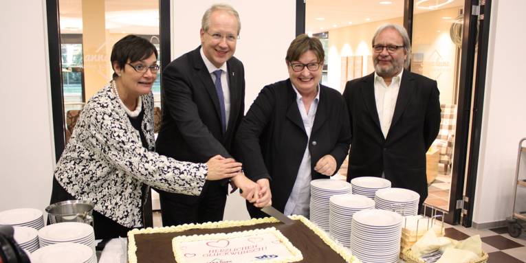 V. Neugebauer (Hannoversche Werkstätten), Oberbürgermeister S. Schostok, Kulturdezernentin M. Drevermann und M. Guttmann (Leiter der VHS) schneiden gemeinsam die Torte an.